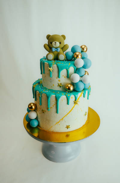 istock A cake with a teddy bear on top and gold and blue decorations 2086734125
