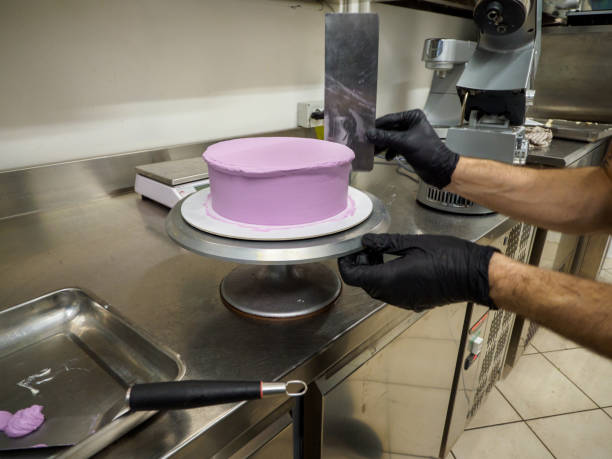 istock Pastry chef preparing a frosted cake in the professional kitchen 2086734128
