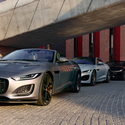 Three F-type Jaguars, cabriolets and coupe, standing in a row at the Katowice concert hall, June 17, 2022