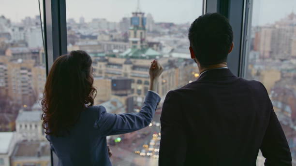 istock Two architects looking city view standing at window high office building closeup 2086737221