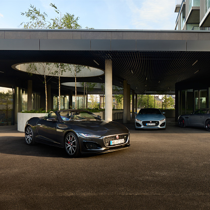 Three convertible Jaguars F type standing parked in front of a modern residential building First District. Katowice, June 17, 2022