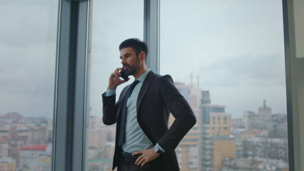 istock Busy ceo calling partners standing office window. Boss giving tasks by telephone 2086751026