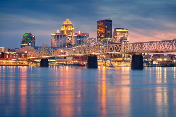 Cityscape image of Louisville, Kentucky, USA downtown skyline with reflection of the city the Ohio River at spring sunset.