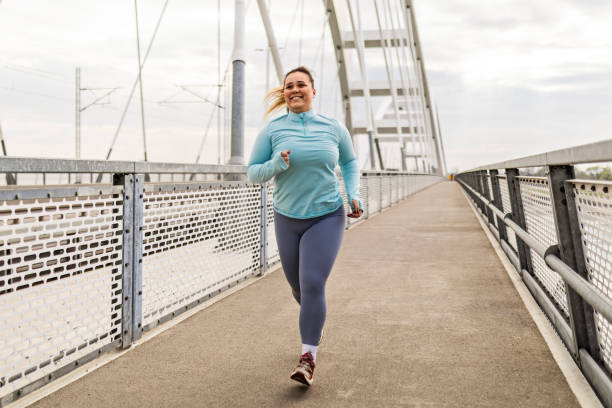 istock Overweight young woman exercising on bridge 2086762892
