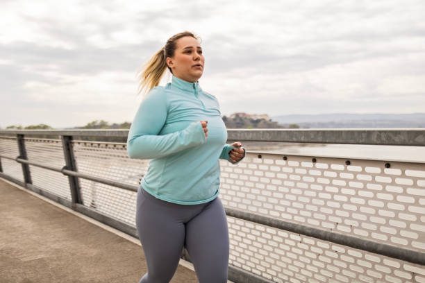 istock Overweight woman running on a bridge 2086762893