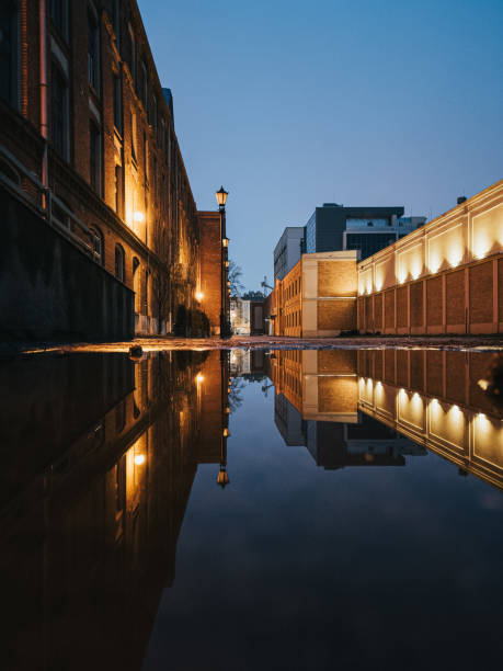 A perspective of courtyard lights seen from an alleyway