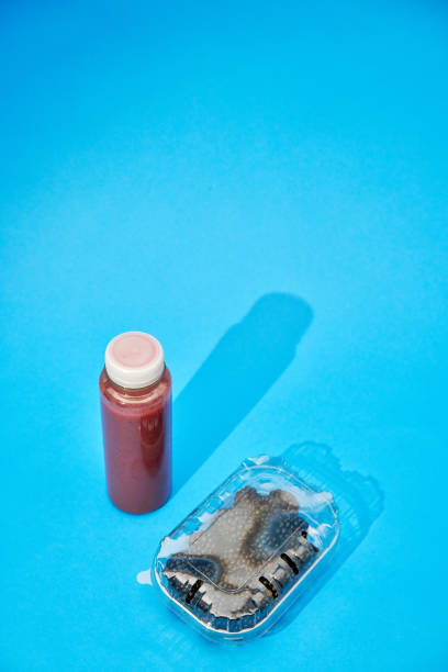 istock Red Smoothie in Recycled PET Plastic Bottle and Fresh Berries in Plastic Packaging on Blue Background 2086862995