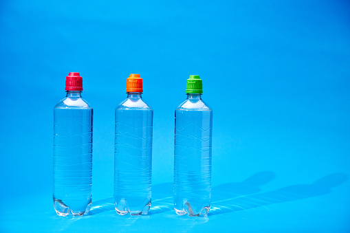 Water in Recycled PET Plastic Bottles on Blue Background
