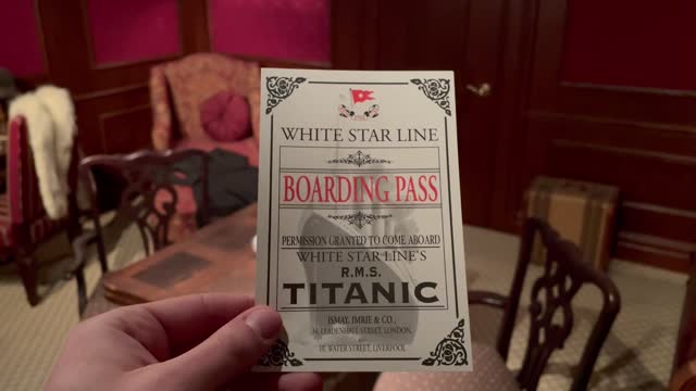 Man holds up a boarding pass to the Titanic in the Titanic in 1912