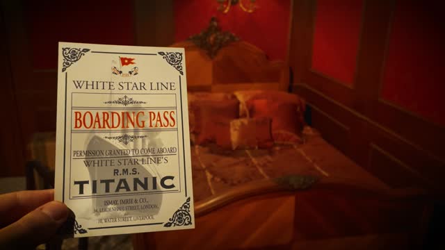 Man holds up Titanic Boarding Pass in Titanic Room in 1912 - Sepia Version