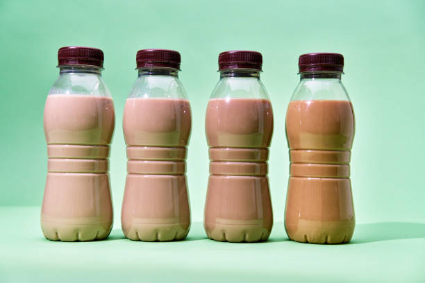 Coffee Latte in Recycled PET Plastic Bottles and fresh Coffee Beans on Green Background