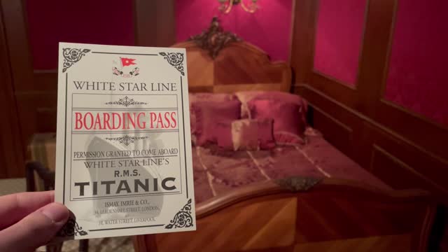 Man holds up Titanic Boarding Pass in Titanic Room in 1912