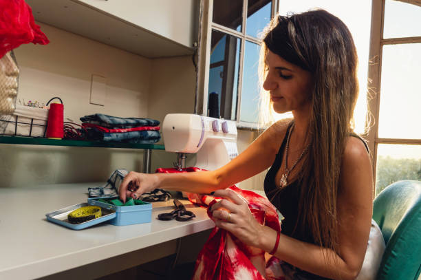 side view of young caucasian woman smiling and working in her sewing workshop - contreras zdjęcia i obrazy z banku zdjęć