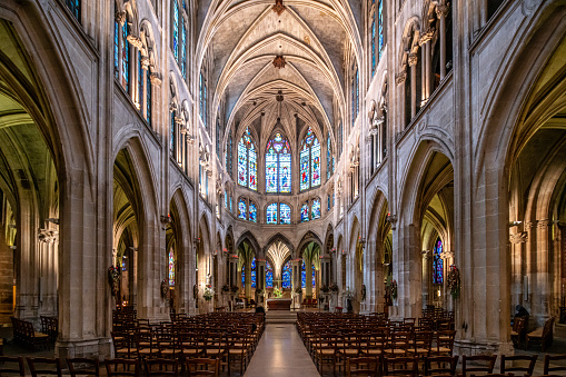 Tranquil ambience inside Saint Severin Church in Paris with evening light filtering through stained glass.