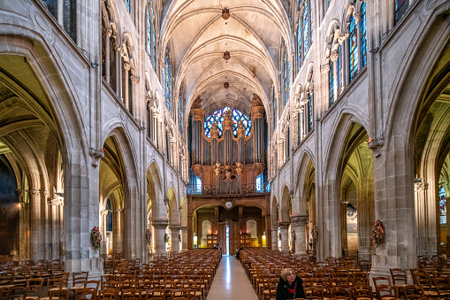 Tranquil ambience inside Saint Severin Church in Paris with evening light filtering through stained glass.