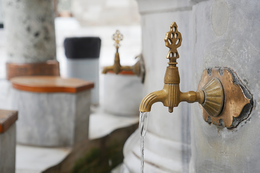 water pouring from a faucet tap outdoor in istanbul .