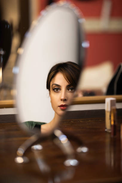 Young dancer/actress putting on makeup backstage to perform