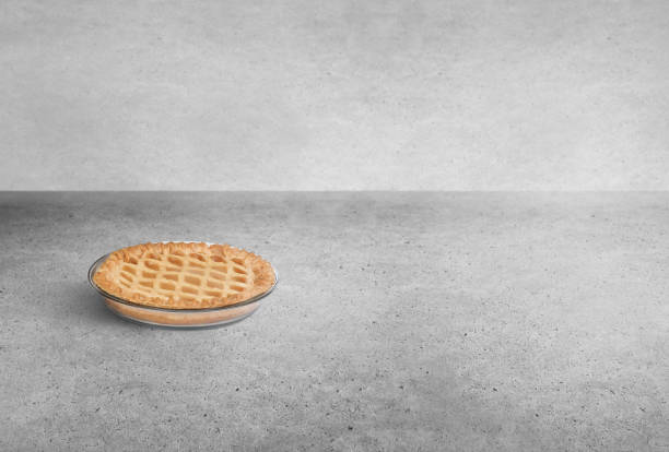 Baked apple pie in a pan on an industrial cement background
