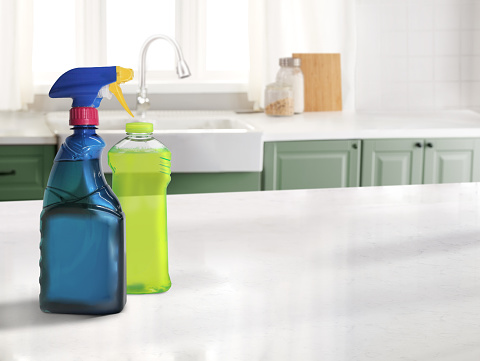 Cleaning products in a spray bottle and a plastic bottle on a counter