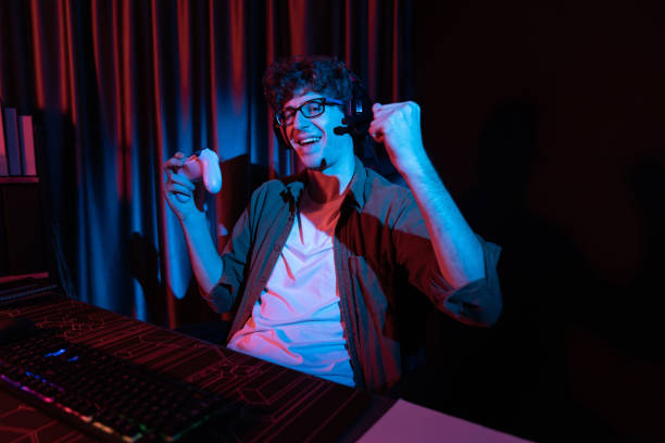 istock Smiling streamer with joystick, focusing Esport team on pc with harder. Gusher. 2087006064