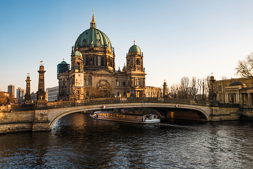 Berlin Cathedral, Berlin, Germany  - 07 March 2024: Cruise ship traveling on the river Spray and Berlin cathedral on a sunny Berlin day.