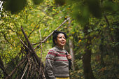 Portrait of a beautiful mid adult woman in front of hut made of branches.