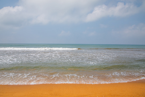 beautiful ocher beach in sri lanka. deserted shore of Indian ocean with bright orange sand. Traditional ordinary local