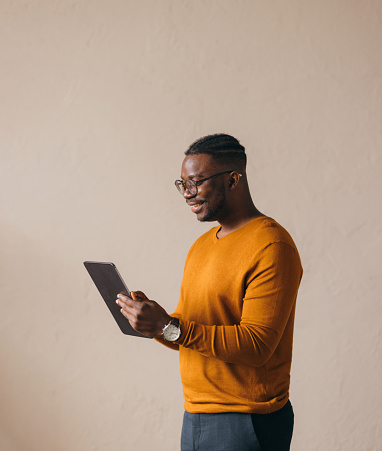 Confident young man in sweater using digital tablet