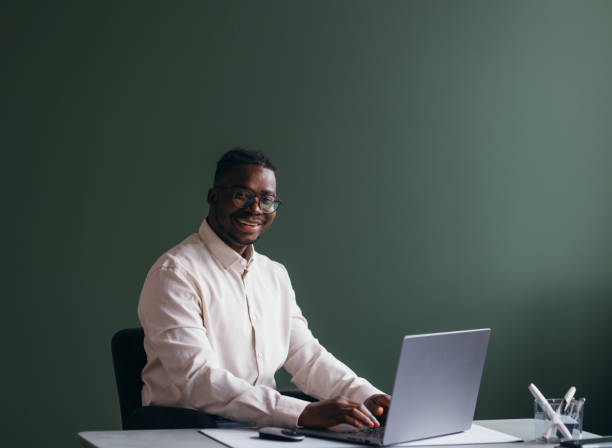 istock Smiling Businessman at Work on Laptop in Office 2087154873