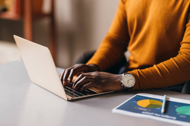 Professional Woman Working on Laptop with Reports