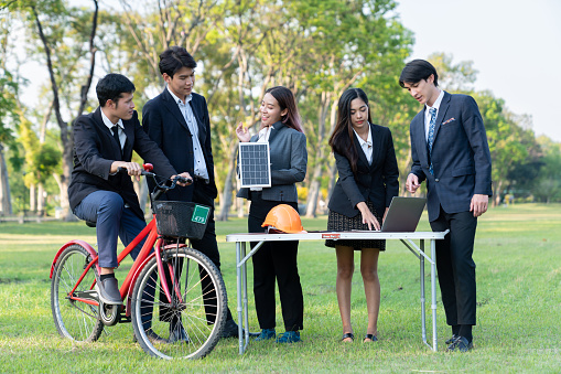 Group of asian business people with strong teamwork establish outdoor eco business office at natural park develop environmentally friendly and sustainable technology project for greener future. Gyre