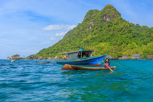 Semporna Sabah, Malaysia - Oct 18, 2017: Sea gypsy paddling a boat in Semporna, Sabah, Malaysia.