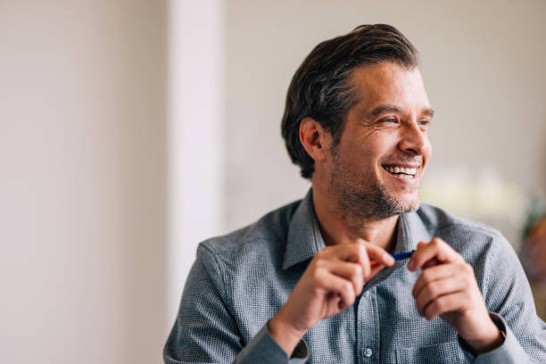 istock Happy Middle-Aged Man Smiling and Looking Away in a Room 2087205968