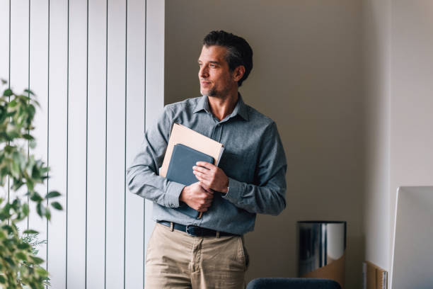 istock Confident Business Professional Holding a Notebook in Office 2087206071