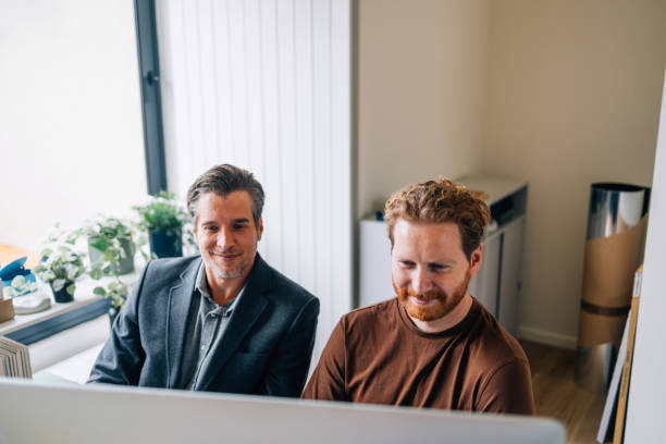istock Two Businessmen Working Together at a Computer in an Office 2087206087