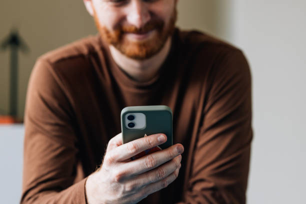 istock Smiling Bearded Man Enjoying Content on Smartphone Indoors 2087206663