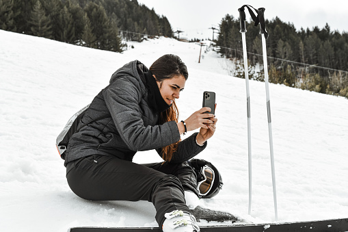Cute Female Using Smartphone To Document Her Skiing Adventures
