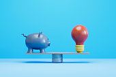 Piggy Bank and Light Bulb on Balance Board, new idea finance concept.
