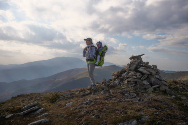 istock Mom with kid in backpack carrier hiking in nature. 2087364677