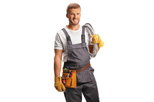 Electrician in a uniform carrying cables on his shoulder isolated on white background