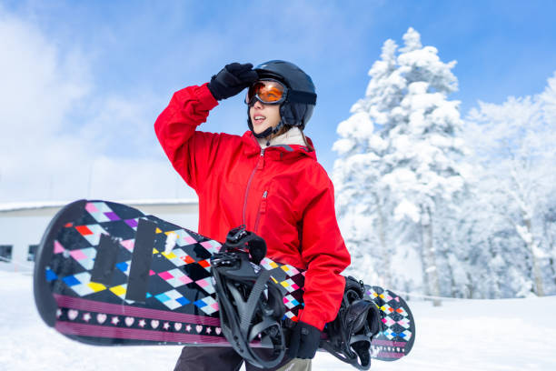 Asian woman practice snowboarding at ski area Portrait of Asian woman practice snowboarding on snow mountain at ski resort. Attractive girl enjoy and fun outdoor active lifestyle travel nature and winter extreme sport training on holiday vacation japanese snowboarder stock pictures, royalty-free photos & images