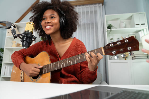 istock American African broadcasting on laptop with playing guitar. Tastemaker. 2087499310