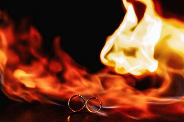 two wedding rings in a flame of fire on a dark background. Wedding. Traditions.