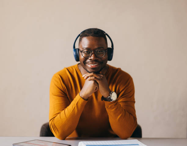 istock Smiling Man with Headphones at Work Desk Professional 2087506012