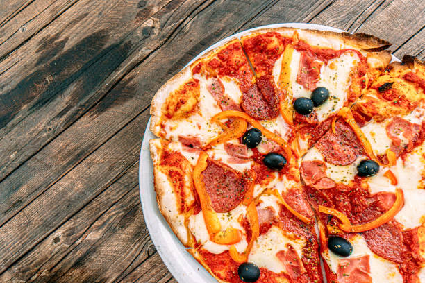Close-Up Shot of Meat & Vegetable Pizza with Black Olives, Red Bell Peppers, Salami, Pepperoni