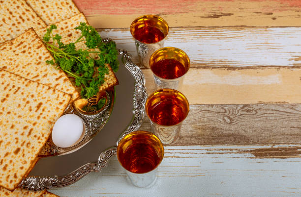 durante pésaj, las familias se reúnen para conmemorar la liberación de los israelitas con vino rojo kosher, un pan sin levadura matzá - passover seder judaism afikoman fotografías e imágenes de stock