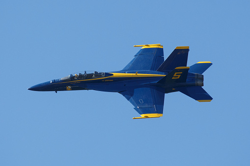 Suisun City, Ca. / USA - March 14 2024: An image of a Blue Angel fighter jet banking left during a practice run two days before the 