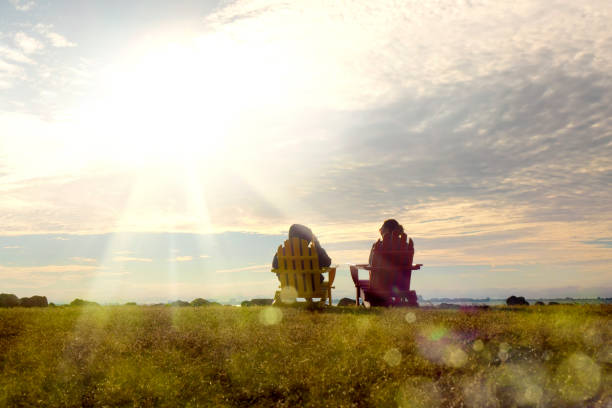 Rear view of two women sitting on Adirondack Chairs and watching view in Florida