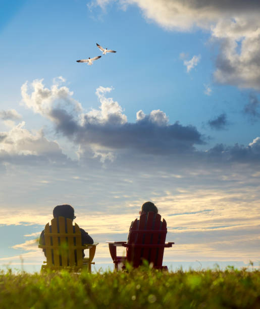 Two women sitting and watching sunset view in nature