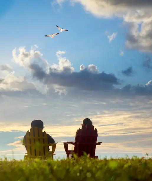 Photo of Two women sitting and watching sunset view in nature